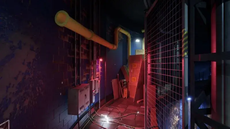 Yellow pipes beside lockers and a wire fence on the exhibit route