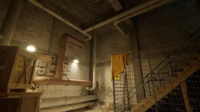 Crate, pipes and a wire cage with yellow cloth above the theater stairs